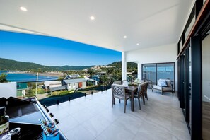 Ein geräumiger Balkon mit Essbereich, Meerblick und modernem Interieur.