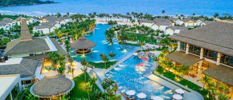 A resort with multiple swimming pools, palm trees, and beachfront views.