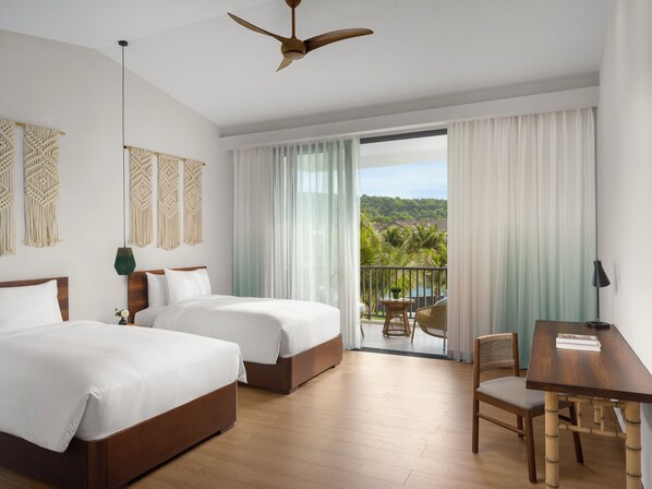 A hotel room with two beds, a balcony with a view of the landscape, and a dining area. - New World Phu Quoc Resort (Phu Quoc)