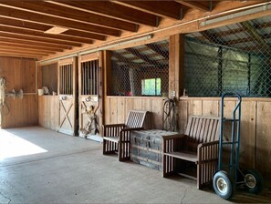 Stable accommodations feature stalls with metal gates and wooden benches.