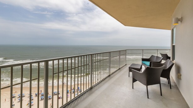 Ein Balkon mit Blick auf Strand und Meer.