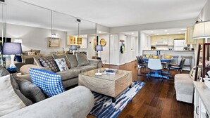 A modern living room with a sofa, coffee table, and dining area. - Relax By Pool: Harbour Town Resort Condo (Hilton Head Island)
