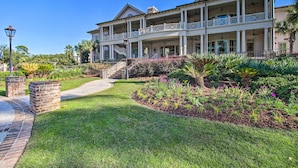 A large, two-story house with a covered porch and a landscaped garden. - Relax By Pool: Harbour Town Resort Condo (Hilton Head Island)
