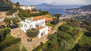 A modern house with a patio, a view of the sea, and a mountainous backdrop. - Villa Dei Golfi , Panorama, Privacy and Quiet (Campania)
