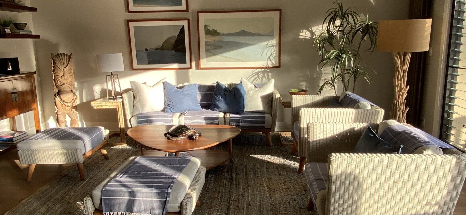 Ein gemütliches Wohnzimmer mit einer Couch, Sesseln, einem Couchtisch und einem Bücherregal.
