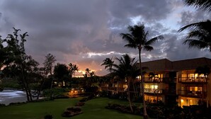 A resort with multiple-story buildings, palm trees, and a well-maintained lawn.