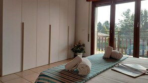 Ein Zimmer mit einem Bett, einem großen Fenster und einer Schiebetür.