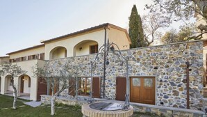 A stone building with arched windows and a central courtyard with a fountain. - La Smarrita by Interhome (Lucignano)