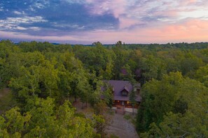 A cabin surrounded by dense forest, with a gravel path leading to the entrance. - Coyote Creek: 3 bedroom, 3.5 bath sleeps 11 (Broken Bow)