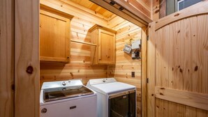 Ein kleiner Waschraum mit Holzwänden und zwei weißen Waschmaschinen.
