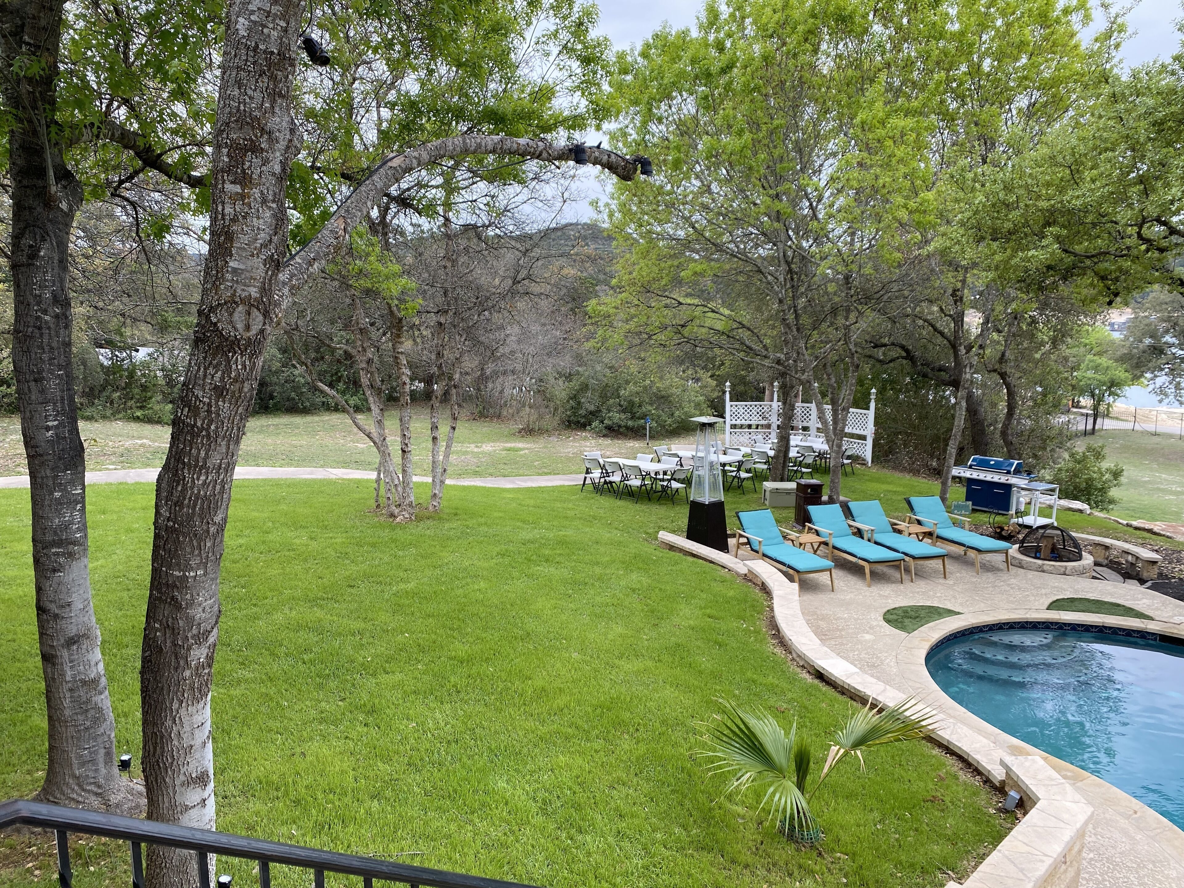 A pool area with lounge chairs and a barbecue grill.