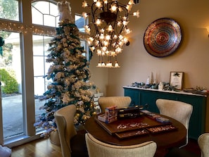 Un comedor acogedor con un árbol de Navidad, una araña y un plato decorativo en la pared.