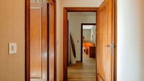 A wooden hallway with a light switch on the left wall.