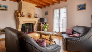 A living room with two leather sofas, a fireplace, and a television. - L'Albizia by Interhome (Gujan-Mestras)