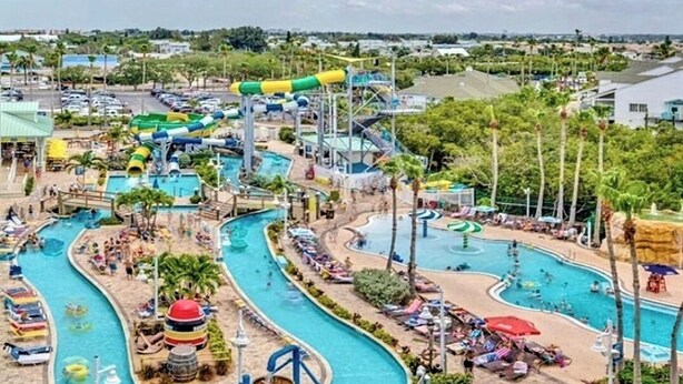 Un parc aquatique doté de plusieurs piscines, de toboggans et d’une grande structure de toboggan aquatique.