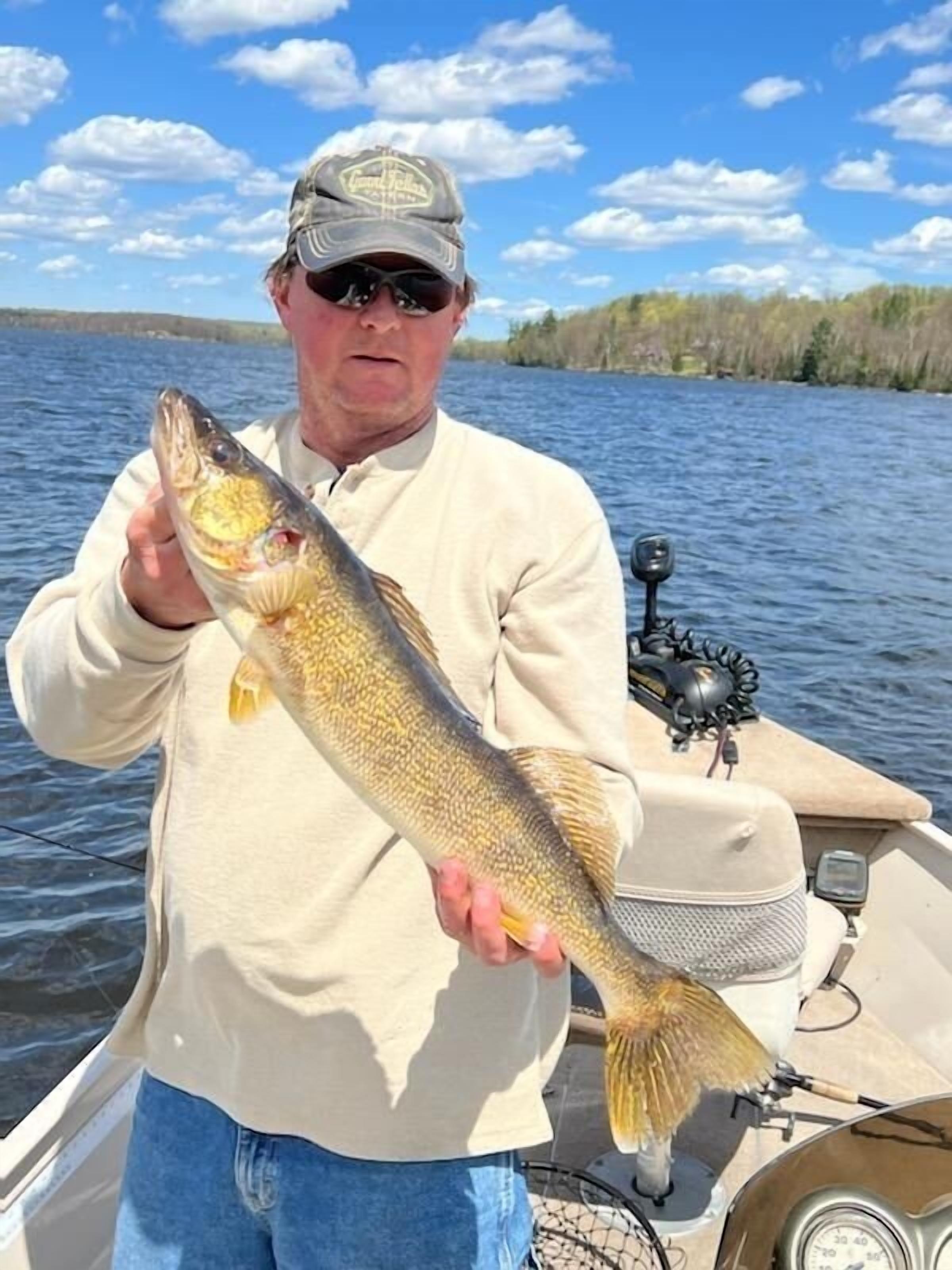 A person holding a fish on a boat.