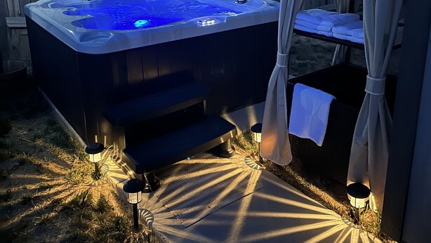 A hot tub with steps, surrounded by a wooden fence, and a canopy tent. - Cabin with Spa and Arcades 7 mins to Ski Resort (Running Springs)