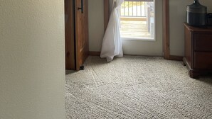 A room with a wooden door, a white curtain, a lamp, and a framed picture on the wall. - Cabin with Spa and Arcades 7 mins to Ski Resort (Running Springs)