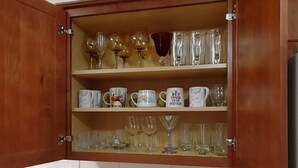 Eine Küche mit Holdekor-Schränken, einer Marmorarbeitsplatte und einem Weinkühlschrank.