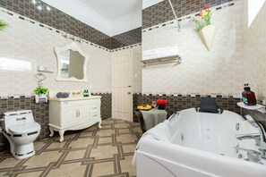Een badkamer met een wit toilet, een witte wastafel, een witte badkamermeubel met een spiegel, een bad en een handdoekhouder.
