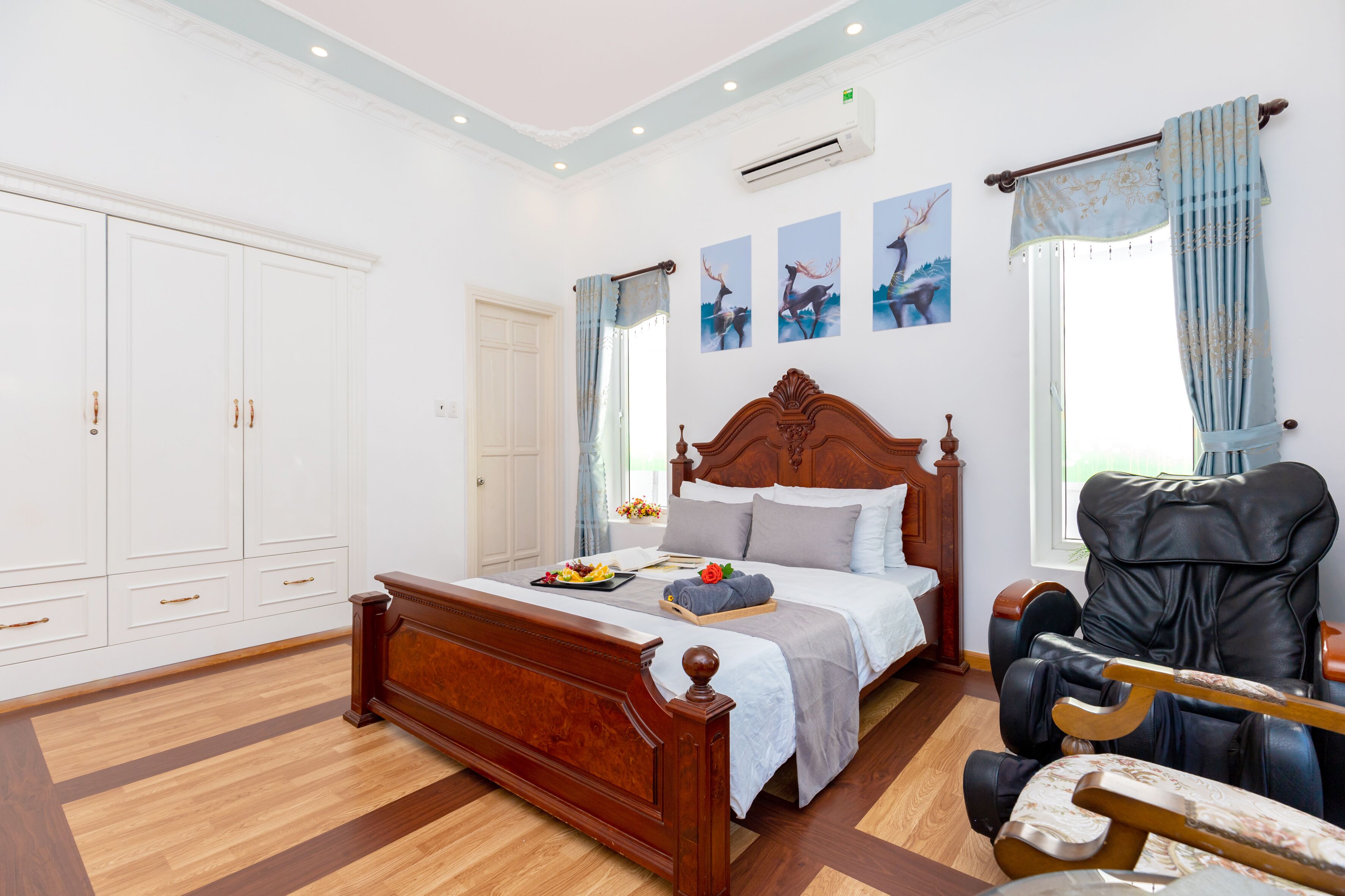 Een slaapkamer met een houten bed, een massagestoel en een grote kledingkast.