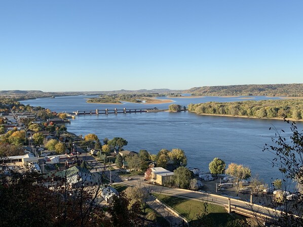 Une ville riveraine avec un pont, des maisons et des véhicules de loisirs.