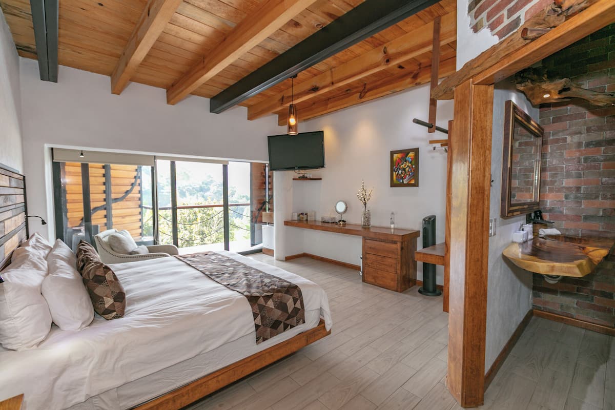 Un dormitorio amplio con una cama grande, un escritorio y un televisor.