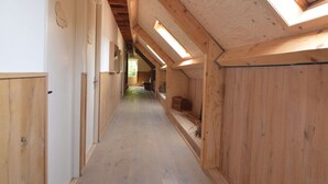 A narrow hallway with wooden walls and a sloped ceiling with skylights. - Holiday Home in Haaren Near De Efteling (Haaren)