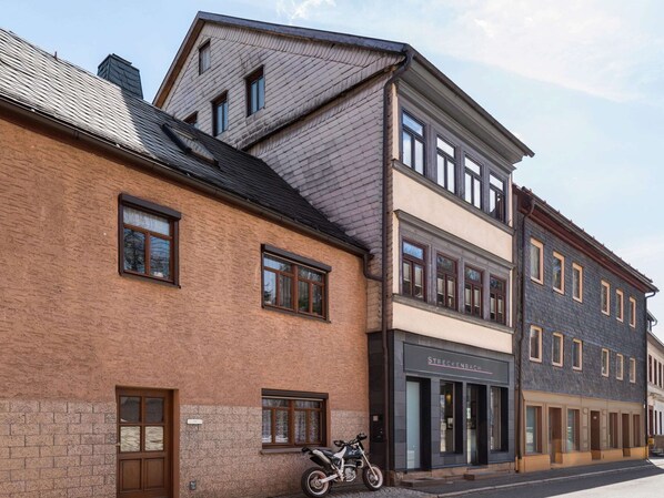 Un immeuble à plusieurs étages, doté d’une façade en briques et d’un commerce au rez-de-chaussée.