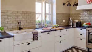 A kitchen with white cabinets, a black countertop, and a checkered floor. - Sprawling Farmhouse in Baarlo With Hot Tub, Private Garden (Baarlo)