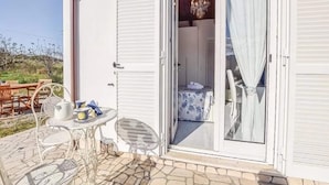 Une pièce dotée d’une porte-fenêtre coulissante donnant sur un balcon aménagé avec du mobilier d’extérieur.