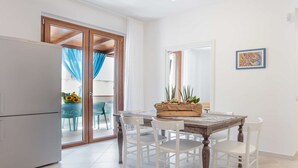 Une cuisine équipée d’une table à manger, de chaises et d’un réfrigérateur.