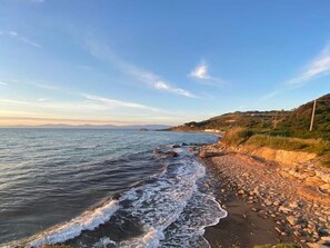 A coastal beach with a rocky shoreline and a clear view of the sea. - Belvilla by OYO Botti House (Agropoli)