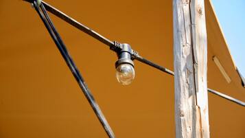 A close-up of a light fixture attached to a wooden post.