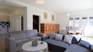 Un salon moderne avec un canapé gris, une table basse ronde et un meuble en bois.