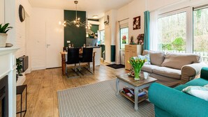 Ein modernes Wohnzimmer mit einer Couch, einem Couchtisch und einem Essbereich mit Stühlen und Tisch.