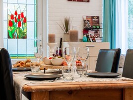 A dining table set with plates, glasses, and a centerpiece.