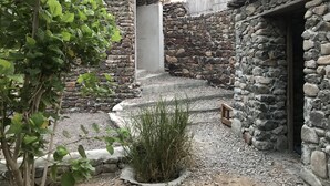 A stone building with a central staircase leading to a door. - Among the Mountains (Mirbah)