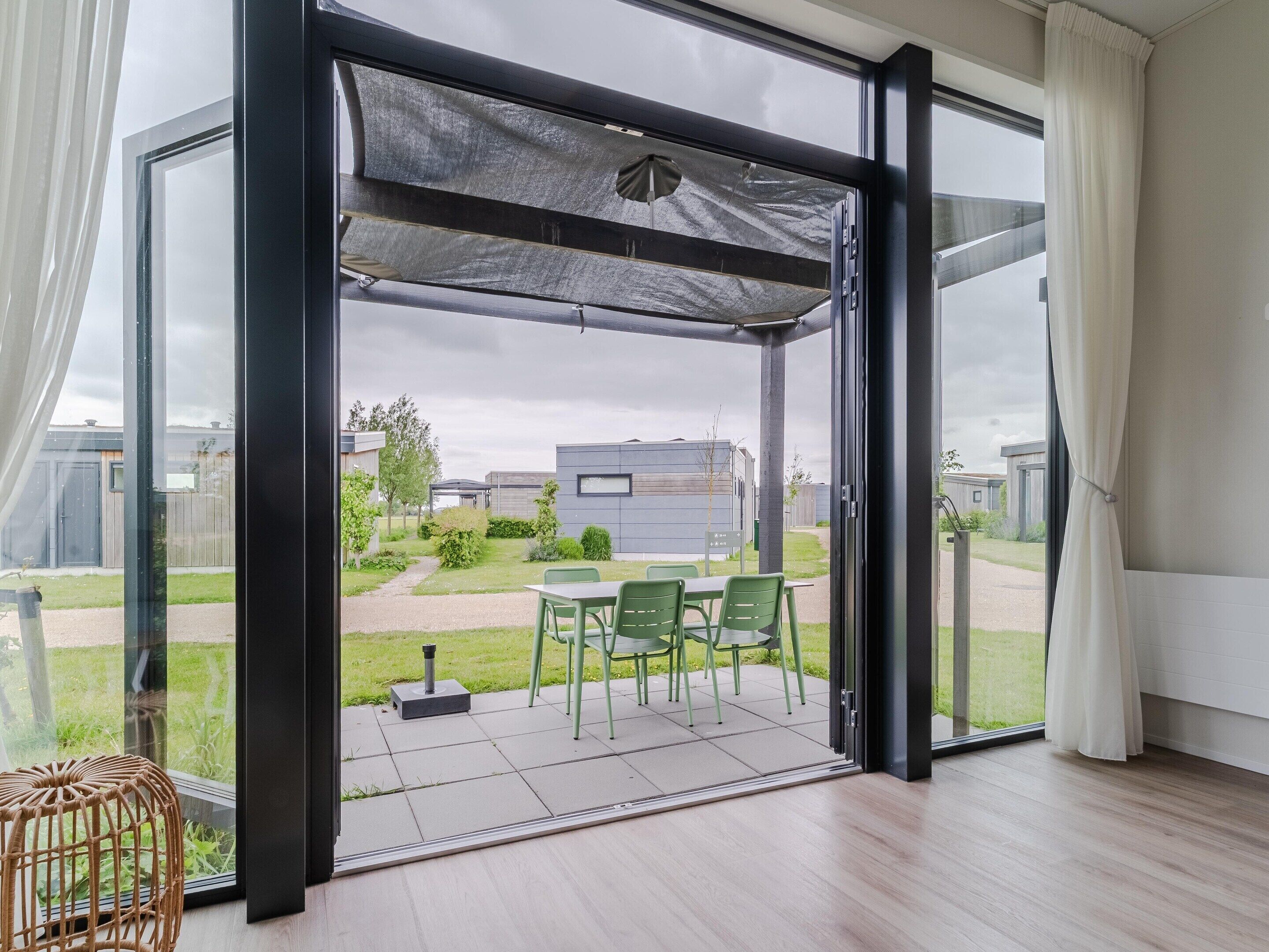 A modern room with a sliding glass door leading to an outdoor patio with a table and chairs.