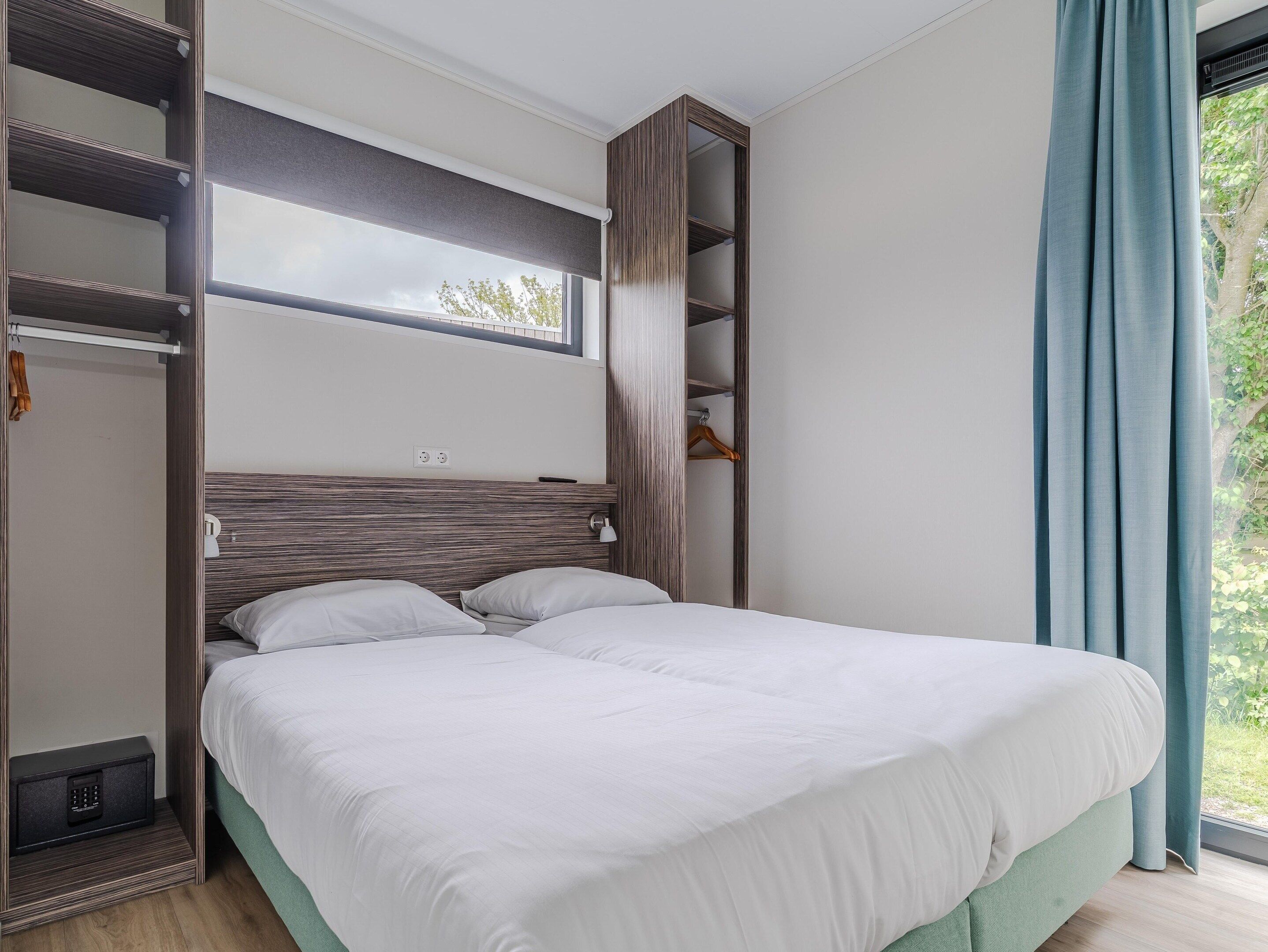 A bedroom with a bed, a wardrobe, and a window.