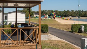 A covered outdoor seating area with a view of a playground and beach. - Neat Chalet With Microwave, Near Antwerp (Rijkevorsel)