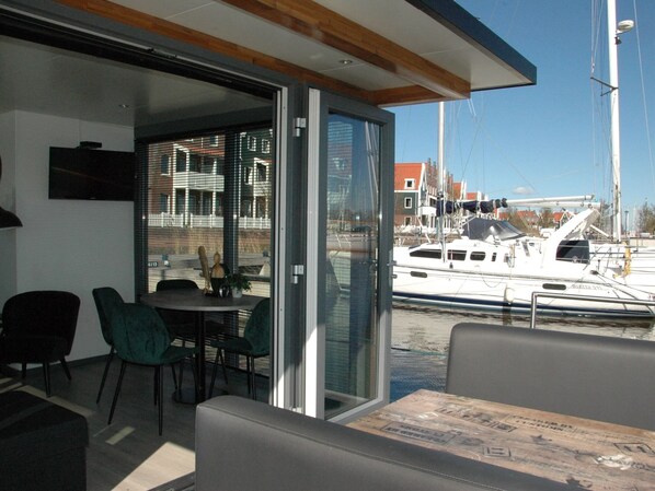 Un intérieur moderne avec une porte vitrée donnant sur un balcon qui offre une vue sur une marina.