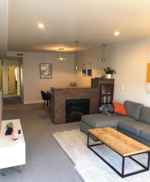 Relax in this inviting living room with a sofa, coffee table, and fireplace.