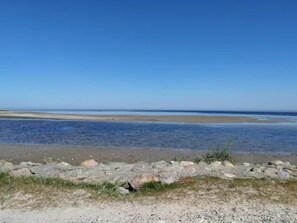 A beach with a rocky shoreline and a clear blue sky. - 6 Person Holiday Home in Hadsund (Hadsund)