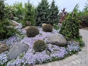 A garden with large rocks, purple flowers, and various trees. - 4 Star Holiday Home in Nordborg (Nordborg)