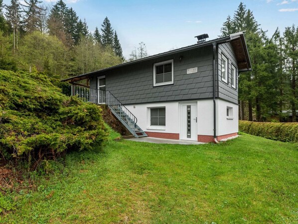 Stunning two-story home surrounded by lush greenery and a well-manicured lawn.