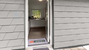 A modern kitchen with white cabinets and a window overlooking a forest. - Home in Steinbach-hallenberg (Steinbach-Hallenberg)