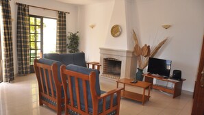 Una sala de estar con chimenea, televisor y mesa de comedor.