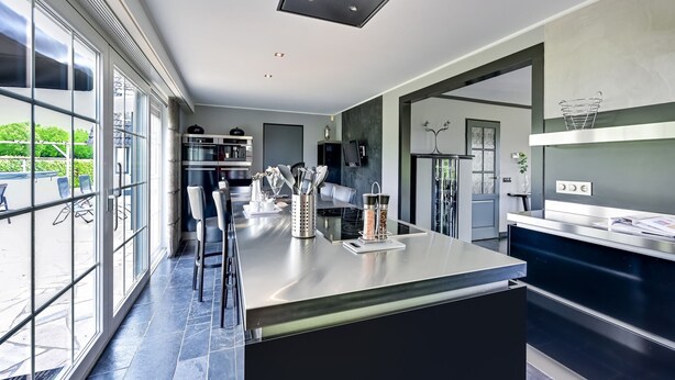 A modern kitchen with a central island, large windows, and a view of the outdoors. - Tasteful Villa in Didam With Garden (Didam)