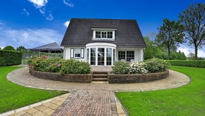 A two-story house with a dark roof, white exterior, and a curved front entrance. - Tasteful Villa in Didam With Garden (Didam)